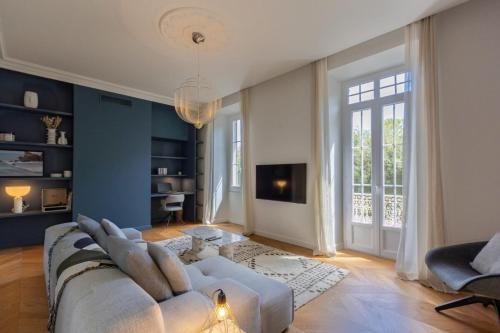 un salon avec un canapé blanc et une grande fenêtre dans l'établissement Casalonga - Prestige Préfecture Comfort - by TGB, à Ajaccio