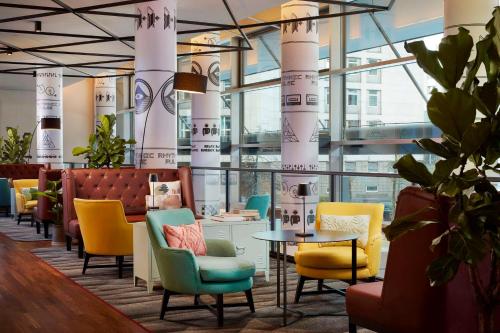 a lobby with colorful chairs and a table at Avani Frankfurt City Hotel in Frankfurt/Main