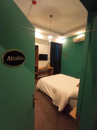 a bedroom with a bed and a green wall at Blue Stone H in Madaba