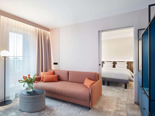a living room with a couch and a bed at Novotel Hamburg Central Station in Hamburg