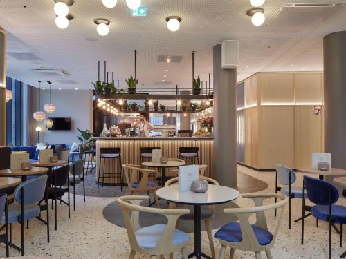 a restaurant with tables and chairs and a bar at Novotel Hamburg Central Station in Hamburg