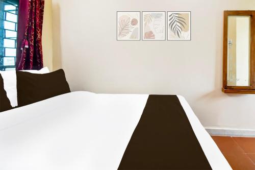a bedroom with a black and white bed and a mirror at Hotel O Khushi Guest House in Bhubaneshwar