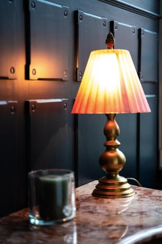 a lamp sitting on a table next to a cup at Domaine Bohème I art de vivre in Guebwiller