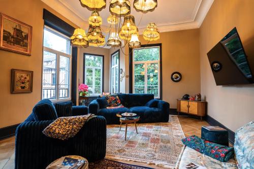 a living room with couches and a chandelier at Domaine Bohème I art de vivre in Guebwiller
