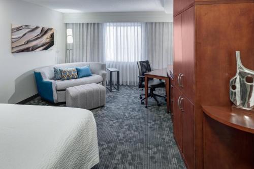 a hotel room with a bed and a couch and a desk at Courtyard by Marriott Birmingham Trussville in Trussville