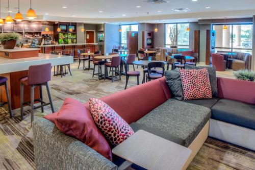 a living room with a couch and a restaurant at Courtyard Mobile Spanish Fort/Eastern Shore in Spanish Fort