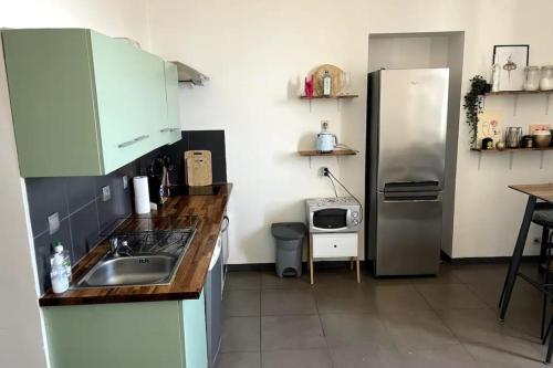 une cuisine avec un évier et un réfrigérateur dans l'établissement Jenna - Sea view Cozy City trip - by TGB, à Ajaccio