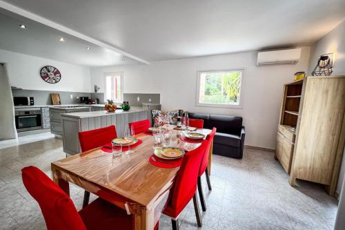 une cuisine et une salle à manger avec une table et des chaises rouges dans l'établissement Shirley - Villa for 10 Pool Terrace - by TGB, à Cuttoli-Corticchiato