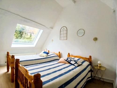 deux lits dans une chambre avec une fenêtre dans l'établissement Domaine d'Ailes - Villa de charme au coeur de la nature avec piscine, à Saint-Florent-sur-Cher