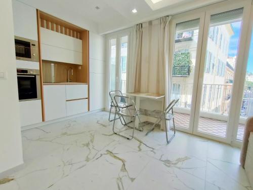 une cuisine avec une table, des chaises et des fenêtres dans l'établissement France 105 Super Centrale 2 Pers WiFi AC, à Nice