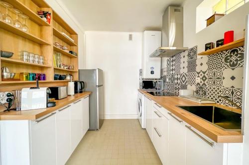 une cuisine avec des armoires blanches et des comptoirs en bois dans l'établissement Martina - Seafront Balcony Spacious - by TGB, à Ajaccio