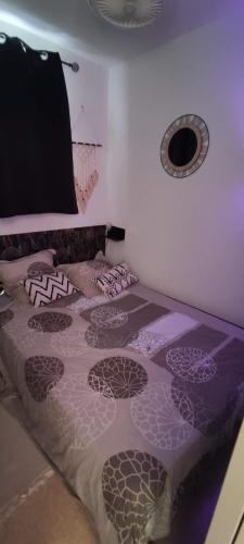 a bedroom with a bed with purple sheets and a window at Appartement 4 personnes port Leucate in Port Leucate