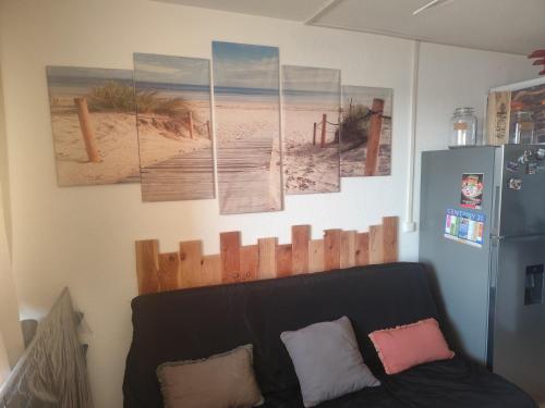 a living room with a couch and some pictures on the wall at Appartement 4 personnes port Leucate in Port Leucate