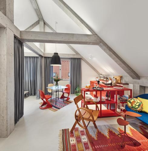 a living room with red chairs and a table at Engelwirt Hotel & Apartments in Berching