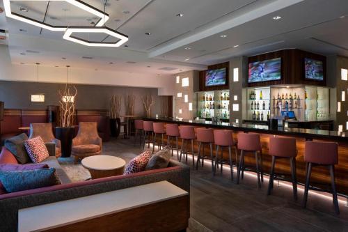 a bar in a hotel room with red chairs at Courtyard by Marriott New Orleans Downtown Near the French Quarter in New Orleans