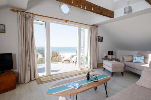 ein Wohnzimmer mit Blick auf das Meer in der Unterkunft Bright & Dreamy On the Beach Garden & Balcony in Bracklesham Bay