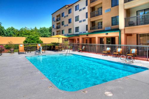 a swimming pool in front of a apartment building at Courtyard by Marriott Burlington in Burlington