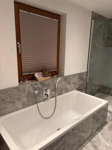 a white tub in a bathroom with a window at Blockhütte Engeln-Eifel in Kempenich