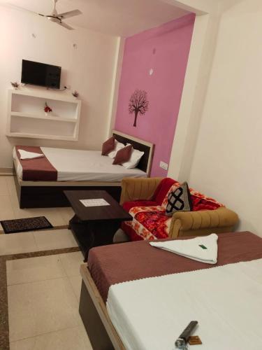 a room with two beds and a living room at Rudra Guest House in Rāmnagar