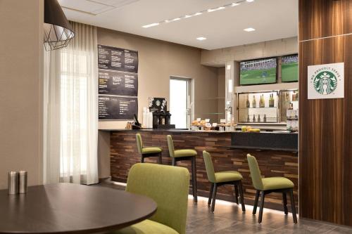a restaurant with a table and chairs and a bar at Courtyard by Marriott St Paul Woodbury in Woodbury