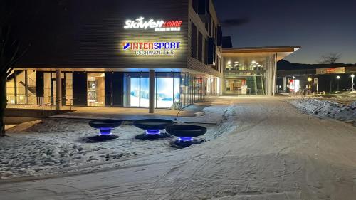 a snow covered street in front of a shopping center at SkiWelt-Lodge Brixen im Thale in Brixen im Thale