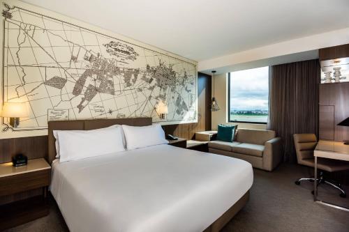 a hotel room with a bed and a map on the wall at Courtyard by Marriott Bogota Airport in Bogotá