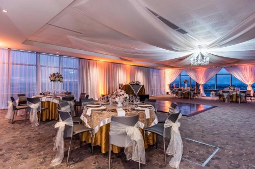 a banquet hall with tables and chairs and windows at Courtyard by Marriott Bogota Airport in Bogotá