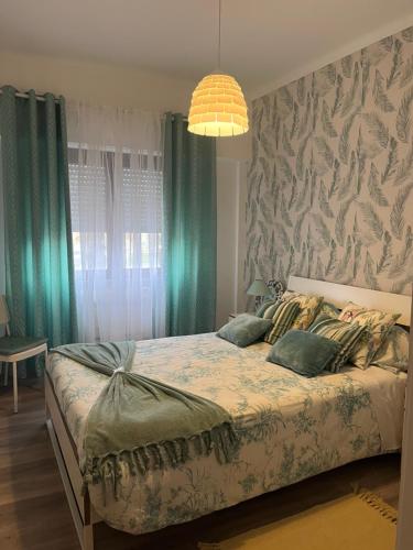 una camera da letto con un grande letto con tende verdi di Apartamento Sado a Setúbal