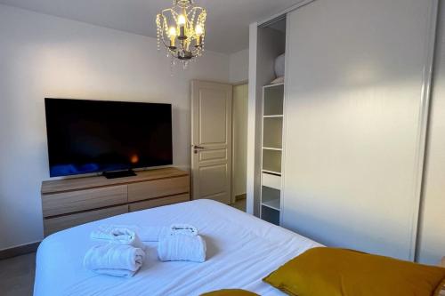 - une chambre avec un lit, une télévision et un lustre dans l'établissement Laetizia - Sanguinaires Sea View Terrace, à Ajaccio