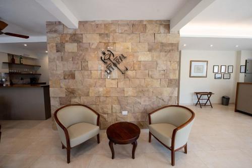 a lobby with two chairs and a stone wall at Hotel Gran Litoral in Concepción del Uruguay