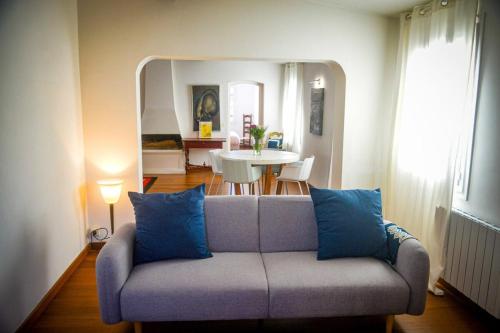 un salon avec un canapé avec des coussins bleus dans l'établissement Rosella - Rooftop Hypercentre - by TGB, à Ajaccio