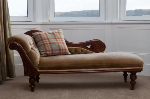 a couch with a pillow on it in a room at Cressfield Country House Hotel in Ecclefechan