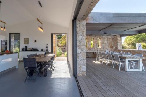 une cuisine ouverte et une salle à manger avec une table et des chaises dans l'établissement Figoni - Unique Villa Pool Superb view - by TGB, à Coti-Chiavari