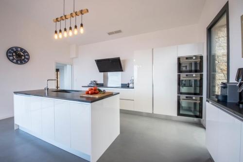 une cuisine avec des armoires blanches et un comptoir dans l'établissement Figoni - Unique Villa Pool Superb view - by TGB, à Coti-Chiavari