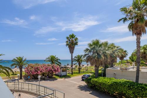 Blick auf einen Parkplatz mit Palmen und das Meer in der Unterkunft Résidence San Pellegrino in Folelli