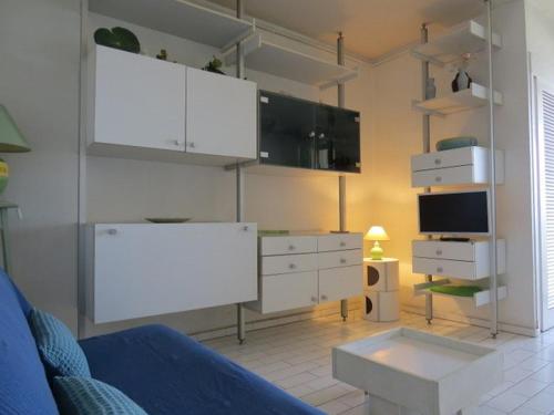 Il comprend un salon doté d'un mobilier blanc et d'une télévision. dans l'établissement AppartementT2 vue panoramique 4ARAX31 Superb loft with panoramic sea view, à Canet