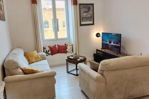 un salon avec deux canapés et une télévision à écran plat dans l'établissement Lympia - Beach & Ferry by foot Balcony - by TGB, à Nice