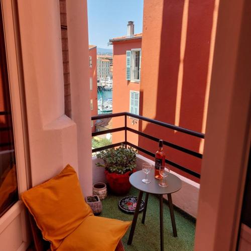 - un balcon avec une petite table et une bouteille de vin dans l'établissement Lympia - Beach & Ferry by foot Balcony - by TGB, à Nice