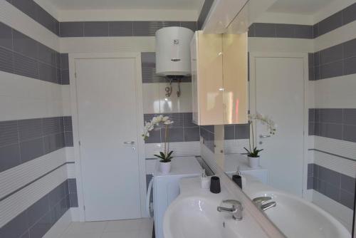 a bathroom with a sink and a tub and a mirror at Villa Isola Bella - Vintage in Mògoro