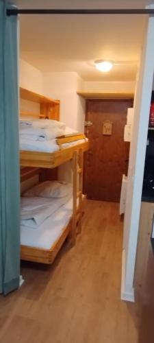 Cette chambre comprend 2 lits superposés et une porte. dans l'établissement Studio à 300M des pistes, à Saint-Jean-dʼAulps