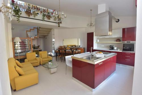 a kitchen and living room with yellow and red cabinets at Villa Isola Bella - Vintage in Mògoro