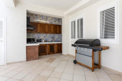 a kitchen with a stove in the middle of a room at Dimora Controvento - IsulaTravel in Ispica