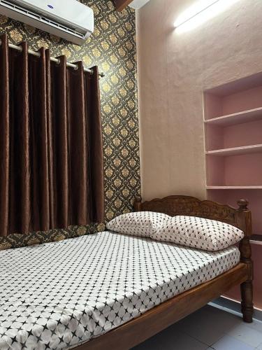 a bedroom with a bed with a window and a curtain at Villa De Pondicherry in Pondicherry