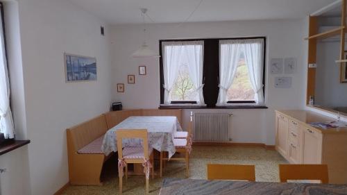 a room with a table and chairs and a window at Casa Vacanza Biasi in Pergine Valsugana