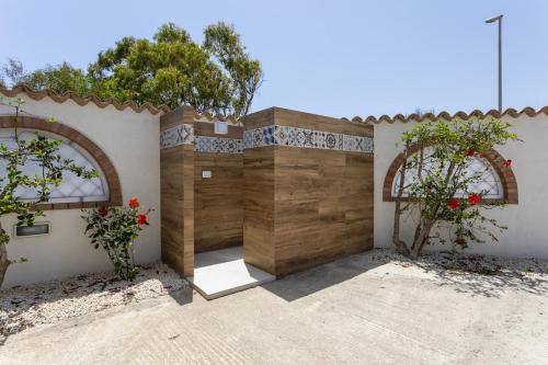 a house with a wooden garage with two windows at Dimora Controvento - IsulaTravel in Ispica