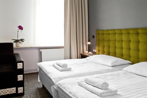 a hotel room with two beds and a yellow headboard at Pokoje Gościnne Tessa in Chełm