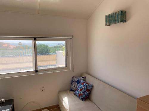 a living room with a couch and a window at Villa sol e mar in Vila do Maio
