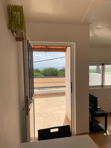 a room with a door to a balcony with a view at Villa sol e mar in Vila do Maio