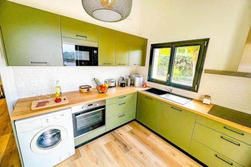 une cuisine avec des armoires vertes et une machine à laver dans l'établissement Marina - Exceptional Sea View Ruppione - by TGB, à Pietrosella