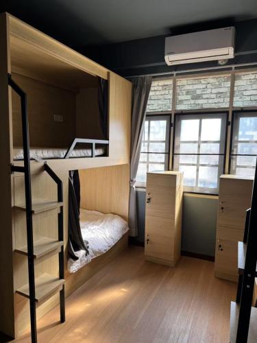 a dorm room with bunk beds and a staircase at The Moment Hostel in Bangkok